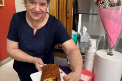 Smiling older adult holding a plate of delicious homemade bread.
