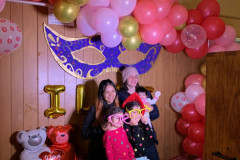 Four smiling children taking posed at a fun photobooth.