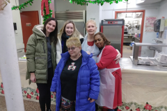 Volunteers and staff with the Catholic Charities Ozone Park Older Adult Center pose for photo while members enjoy their Christmas Day feast,