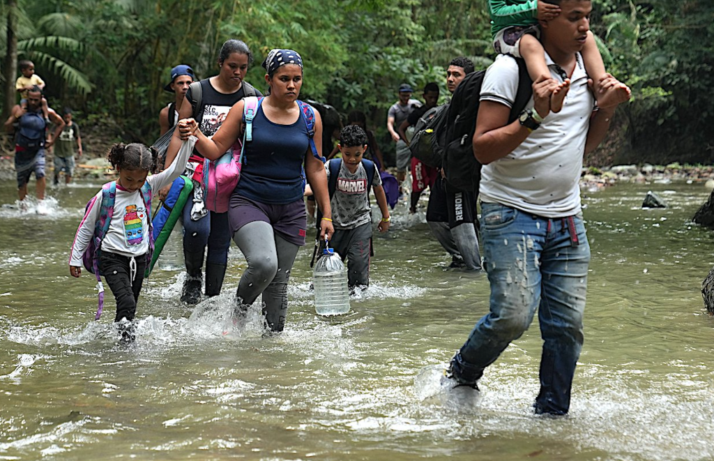 Adult asylum seekers hold on to their children while crossing the Darien Gap.