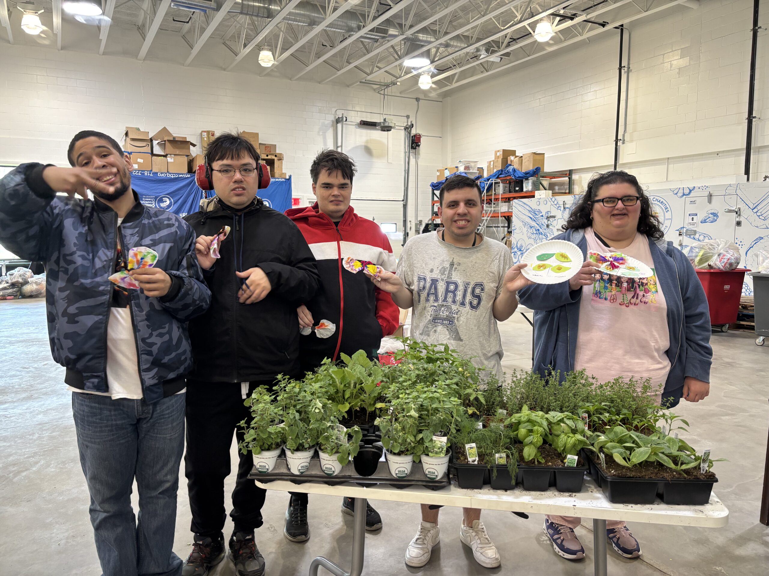 participants in front of a table with plants ready for the bridge building garden project